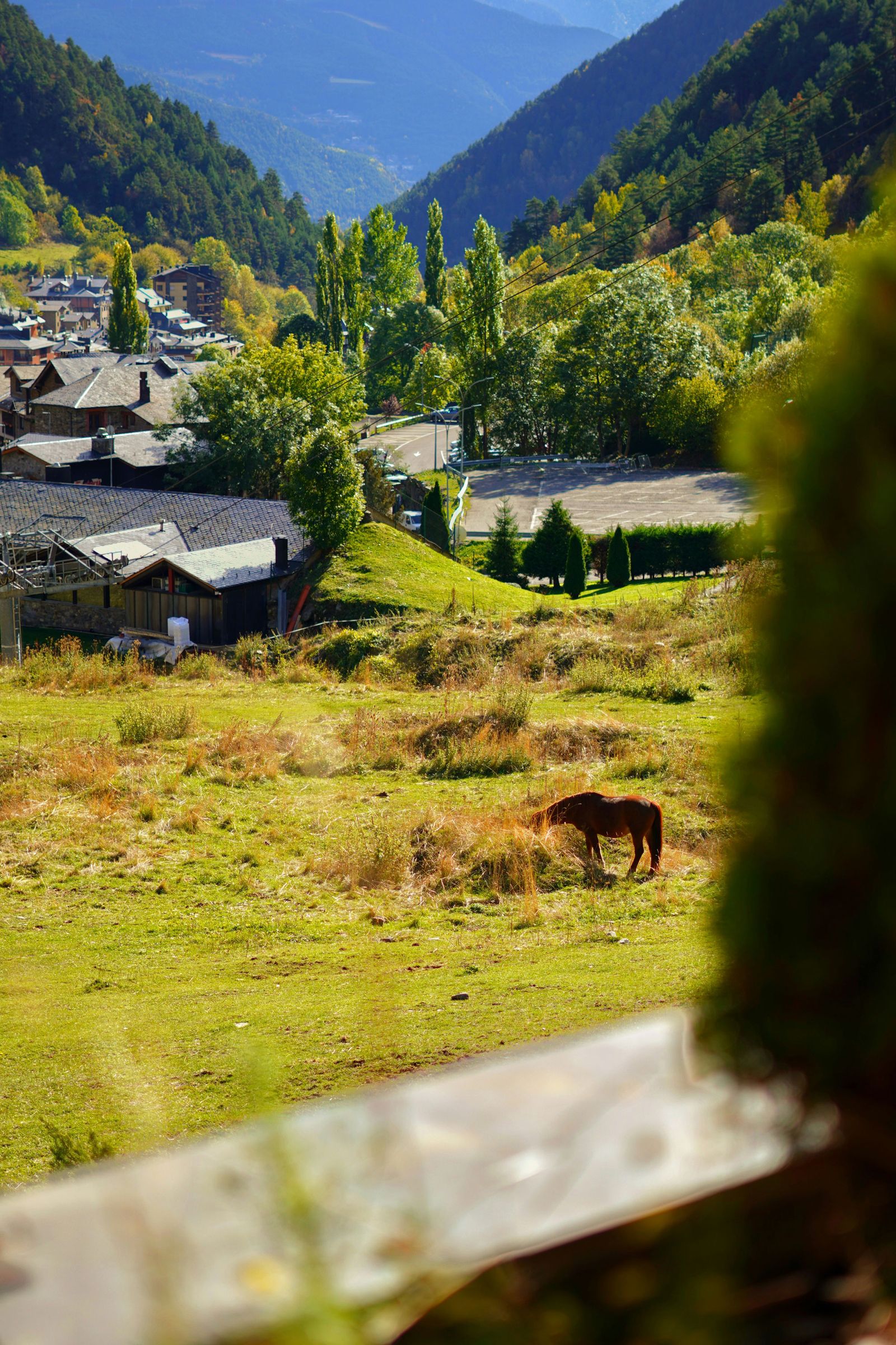 A quiet rural village with stone buildings set against a backdrop of green fields.
