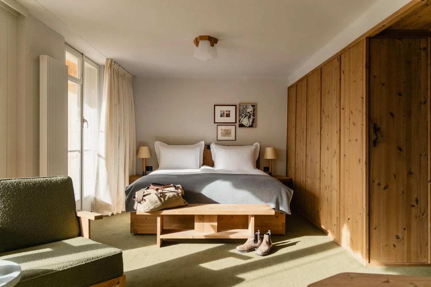 Modern hotel room interior with warm wood accents, white bedding, and bright natural light.