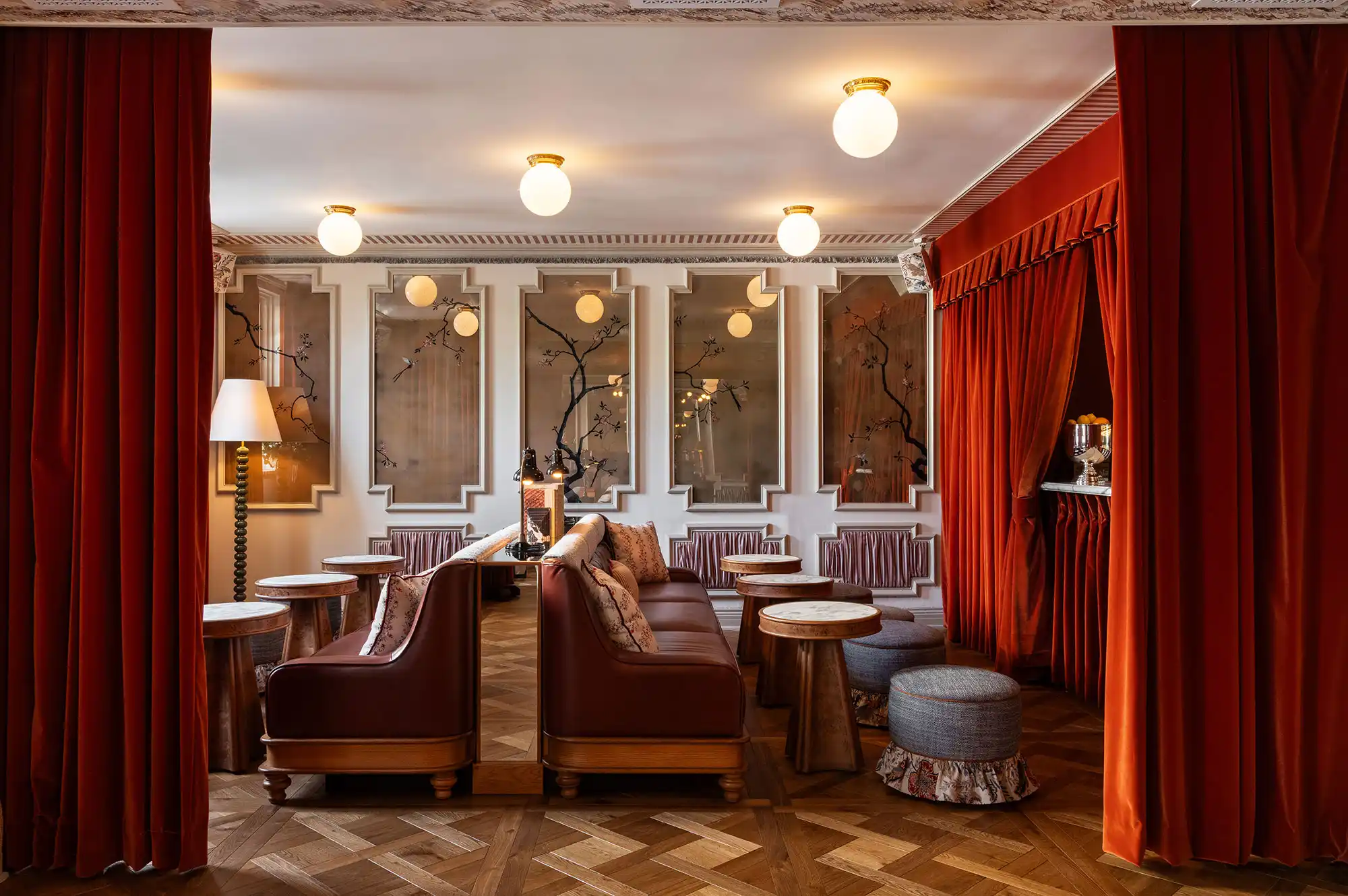 A sophisticated hotel lounge area with red curtains and decorative mood lighting.