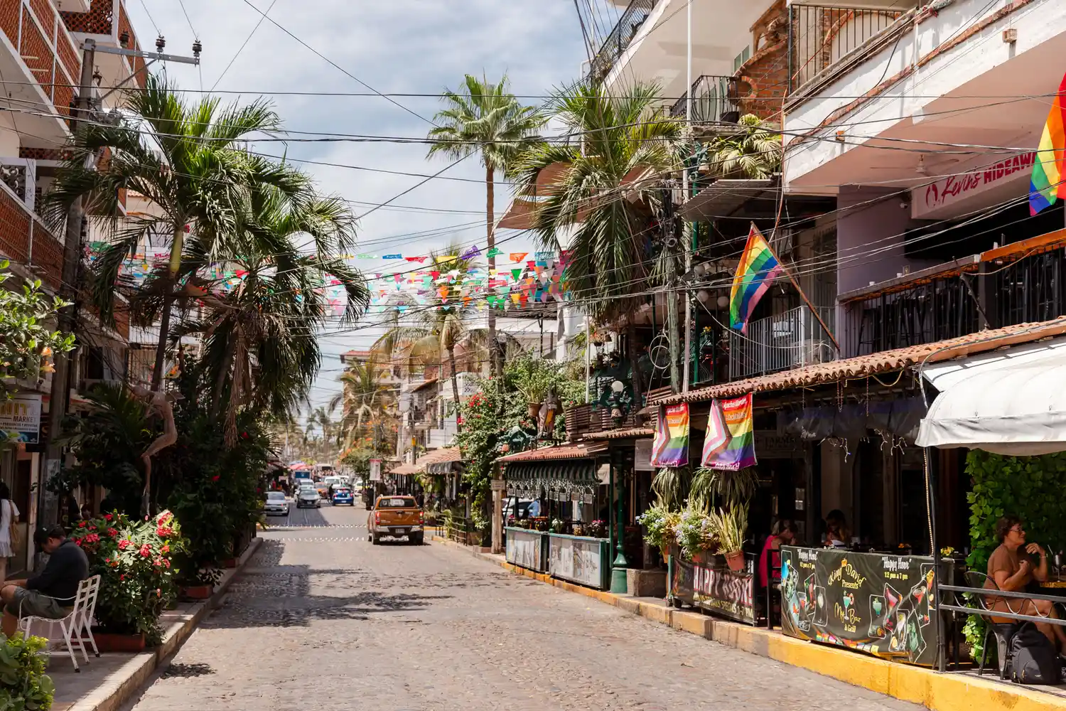 A typical Puerto Vallarta street featuring traditional architecture, palm trees, and cobblestone paths.