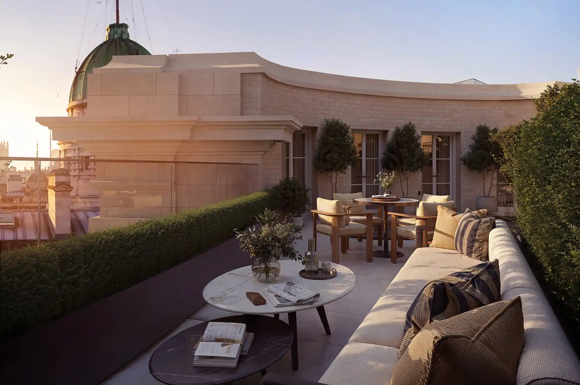 High-angle view of a terrace with outdoor seating and lush greenery overlooking London landmarks.