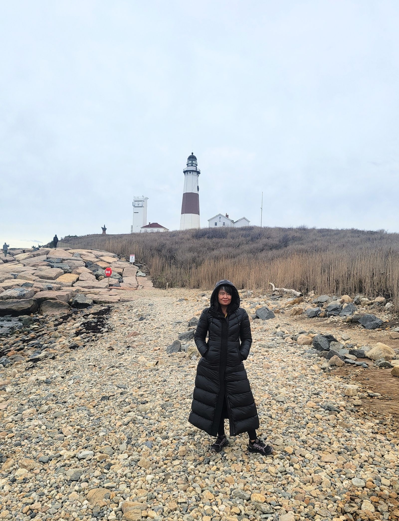 An adult traveler exploring a coastal lighthouse during a retreat excursion.