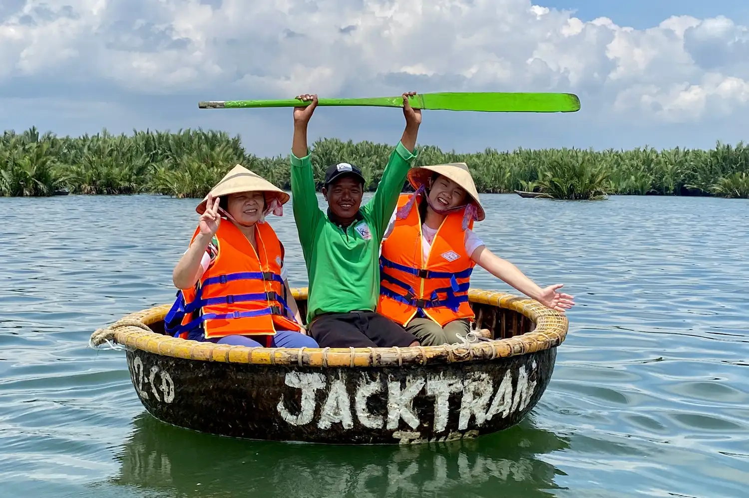 A small group of travelers enjoying a ride in a traditional round bamboo basket boat on the water.