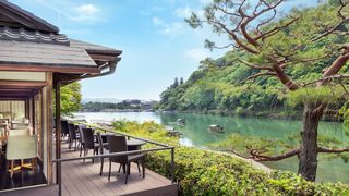 Exterior view of the Suiran hotel nestled in the Arashiyama landscape near the river.