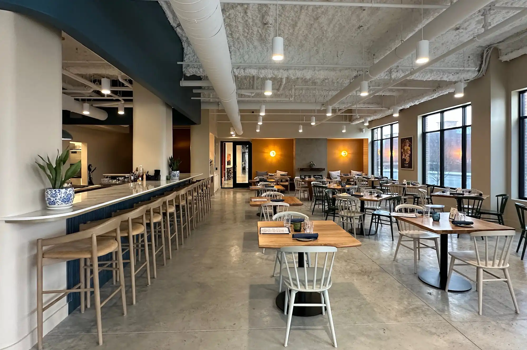 A modern restaurant interior with a bar and sleek seating inside a renovated Dover mill building.