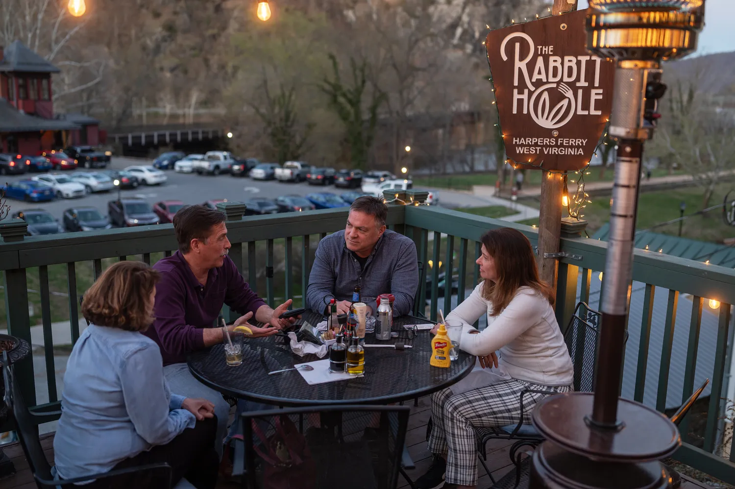 People dining outdoors on a wooden deck at The Rabbit Hole restaurant.