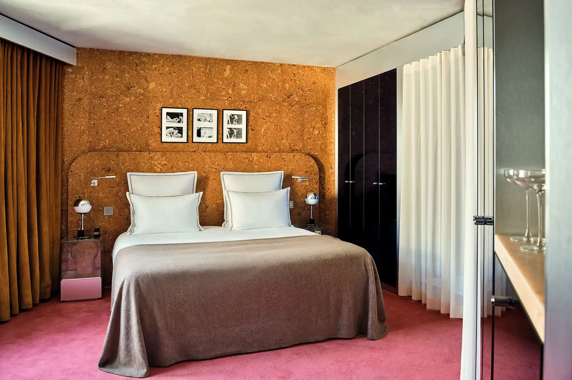 A stylishly designed boutique hotel bedroom with retro-modern decor and framed art.