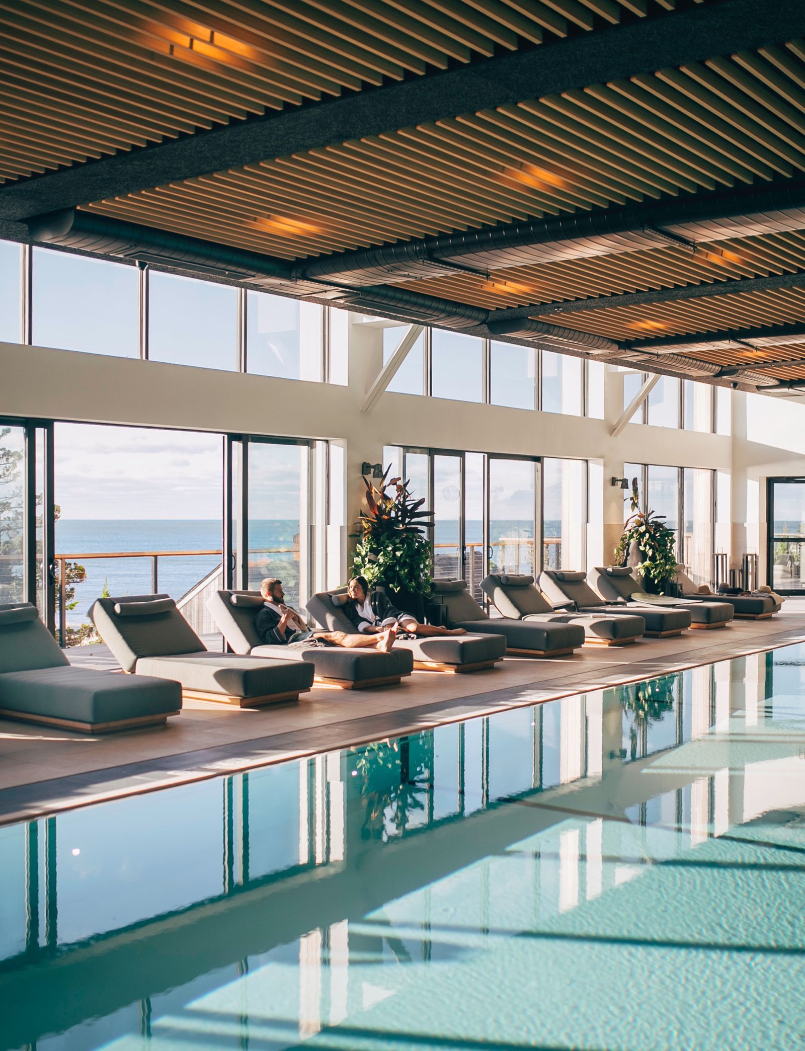 An elegant indoor hydrotherapy pool and lounge area within a luxury wellness resort.