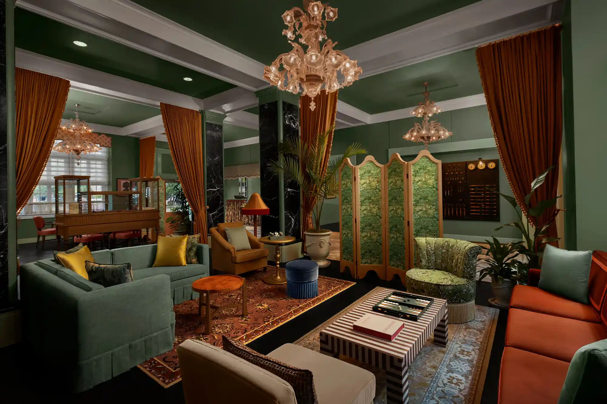 An opulent hotel lobby featuring marble floors, ornate chandeliers, and elegant seating.