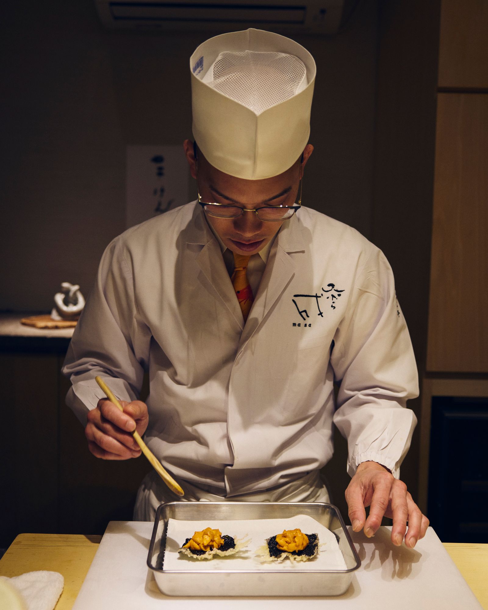 A professional chef carefully preparing a high-end dish with precision tools.