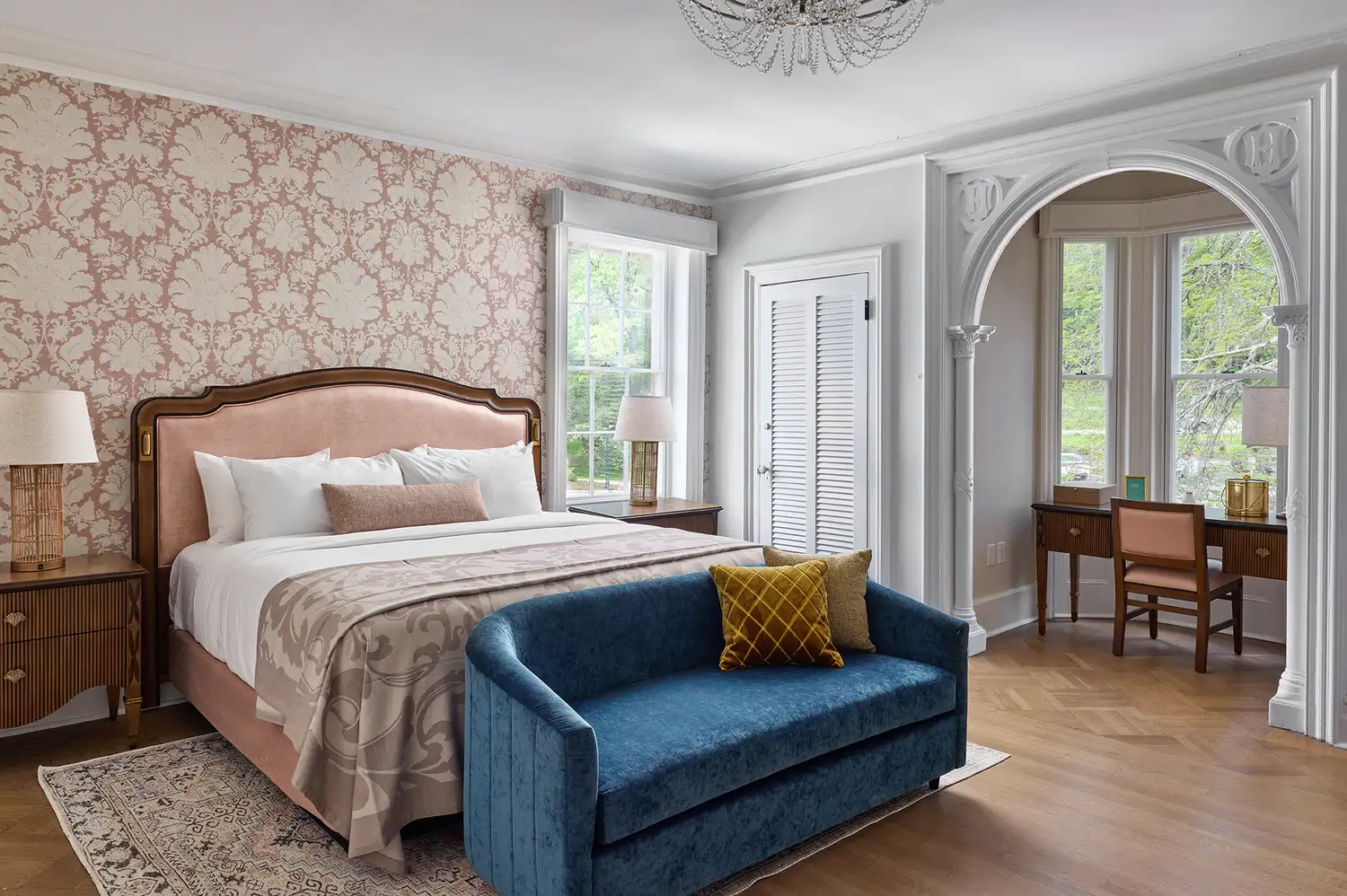 A luxury bedroom suite with a king-sized bed and arched architectural details.