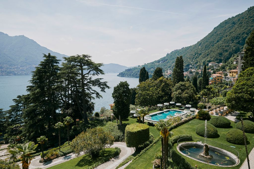 The pale-amber facade of Passalacqua villa surrounded by lush gardens overlooking Lake Como.