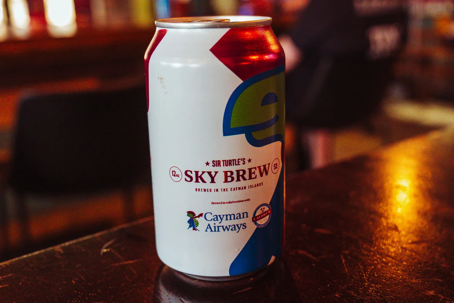 A can of Sir Turtle's Sky Brew beer by CayBrew served on an airplane tray table.