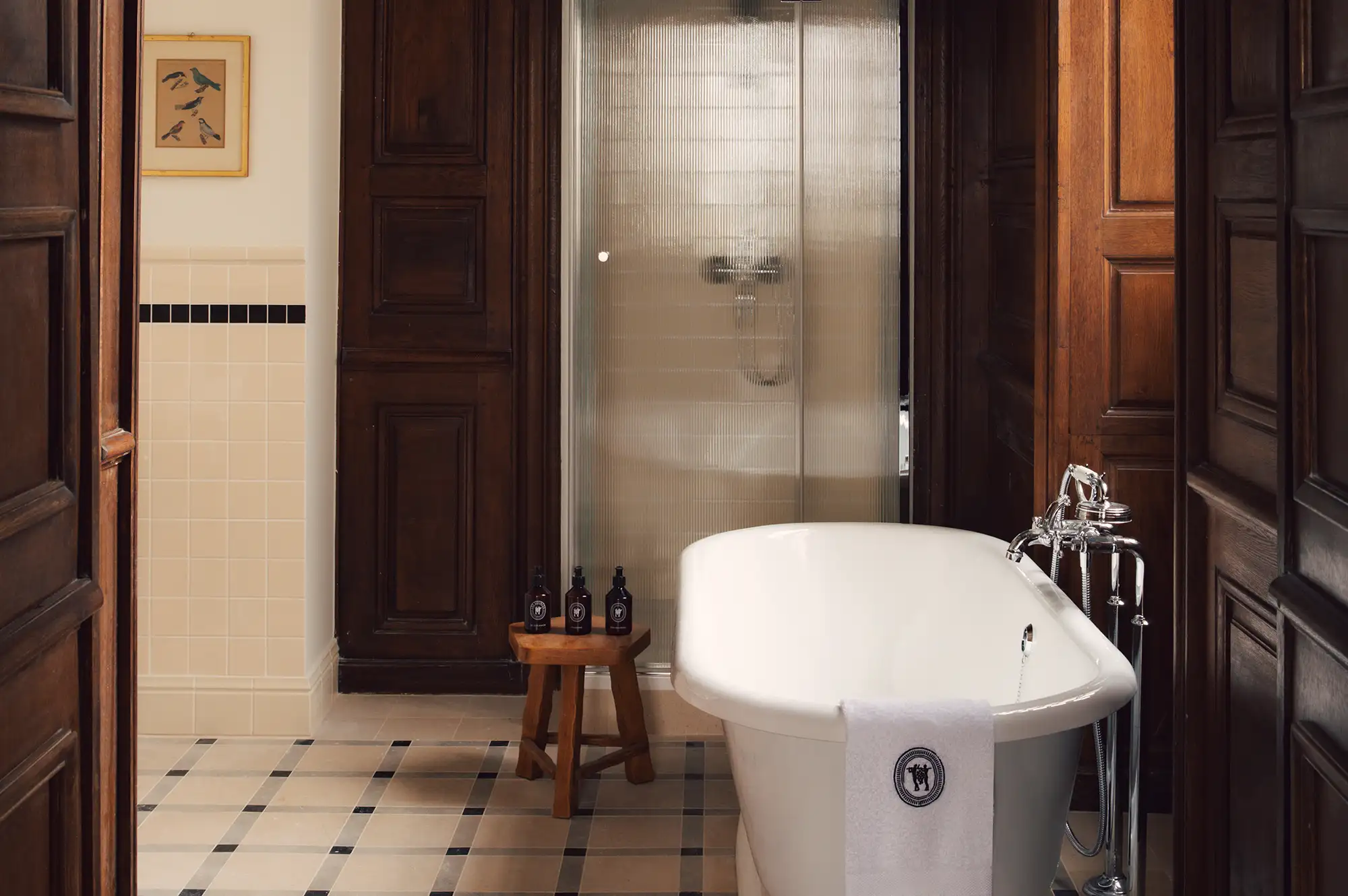 A modern bathroom featuring a freestanding soaking tub and natural wood paneling.
